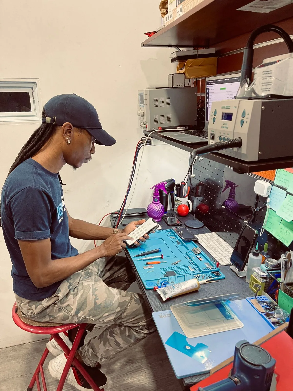A Pinglinks technician repairing a phone at his workbench